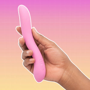 A hand holding a pink curved personal massager against a pink-to-yellow gradient background with a grid pattern.
